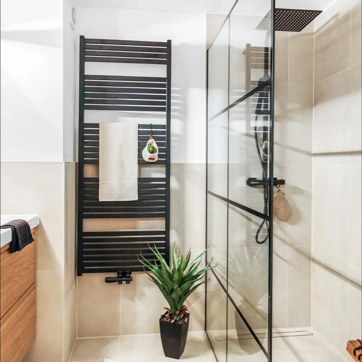 Saniertes Bad in Bad Bentheim mit bodengleicher Dusche, Glaswand und schwarzem Handtuchheizkörper