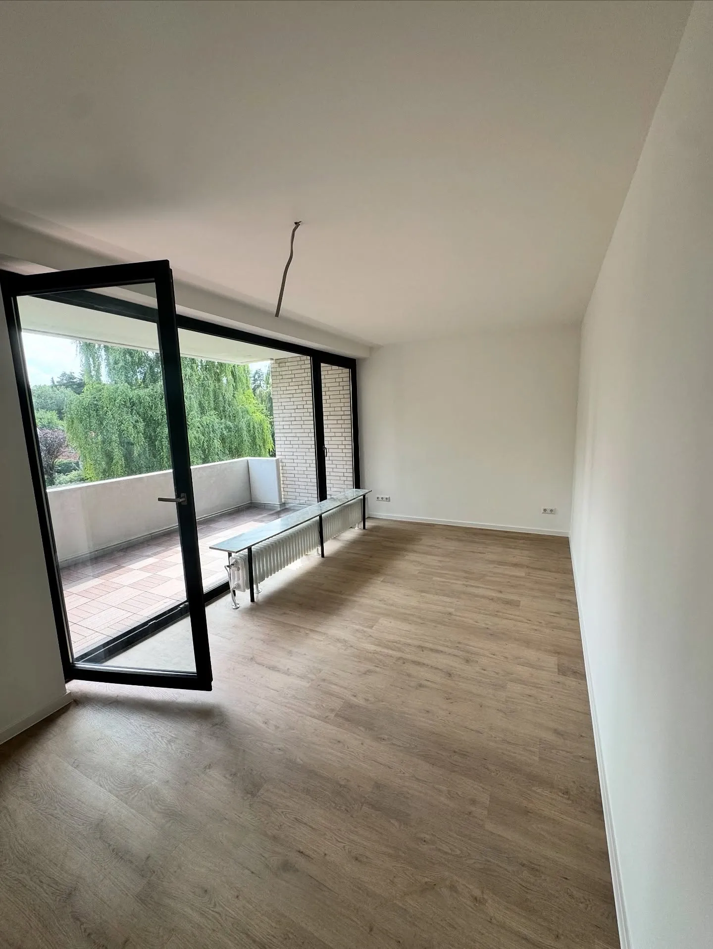 Sanierte Wohnung in Osnabrück: Wohnraum mit neuem Boden und Zugang zum Balkon