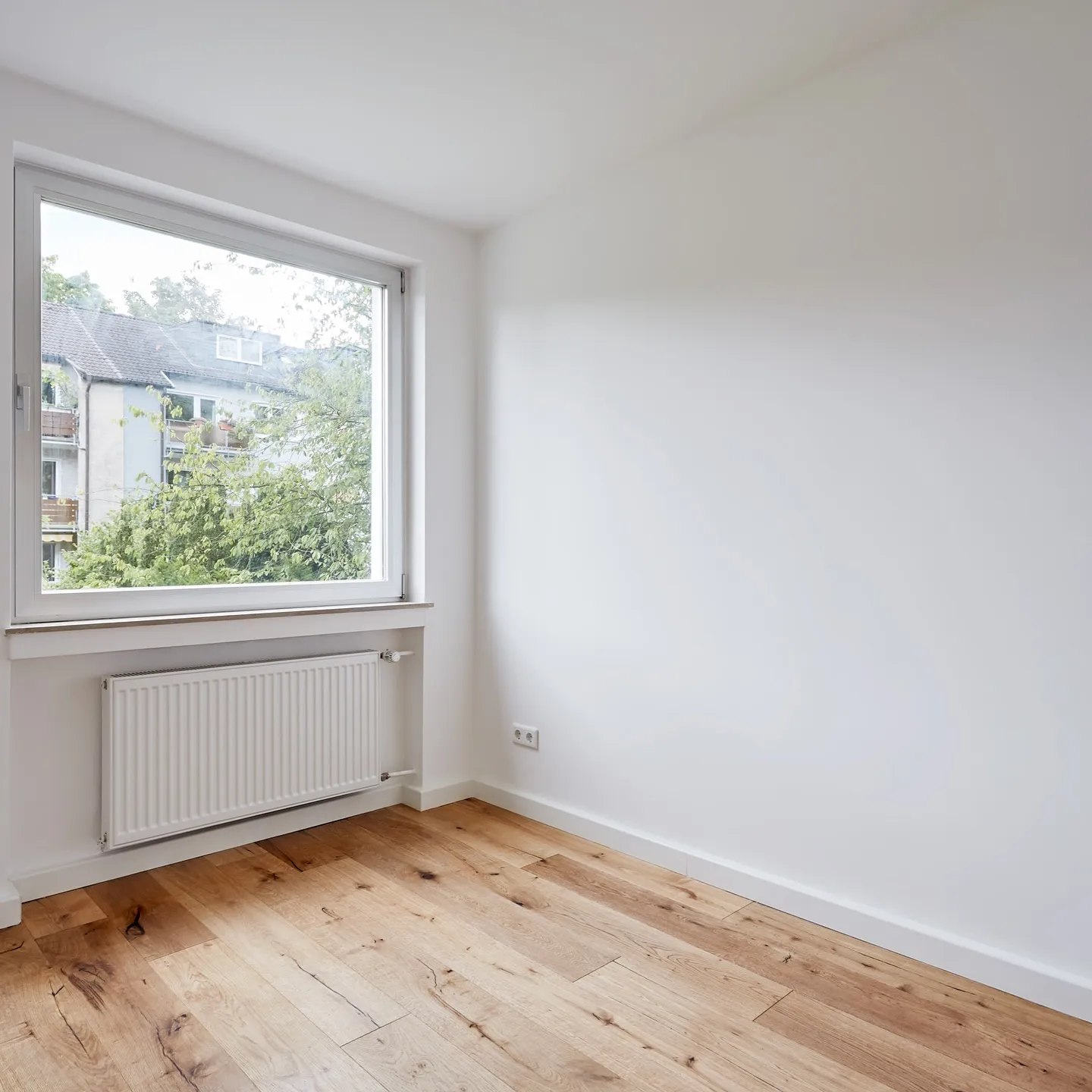 Zimmer der sanierten Wohnung in Haan-Gruiten mit Eichenparkett und Fenster